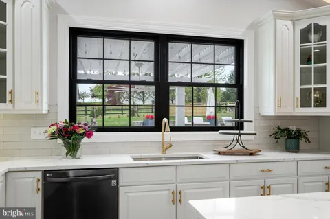 a kitchen with a white cabinets and window