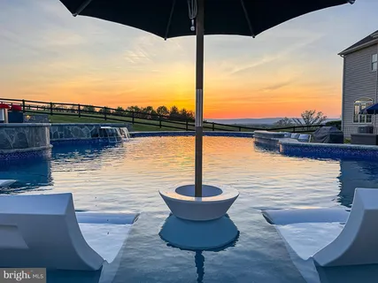 a kitchen with stainless steel appliances a dining table chairs stove and sink