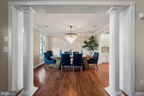 a hallway with white cabinets and wooden floor