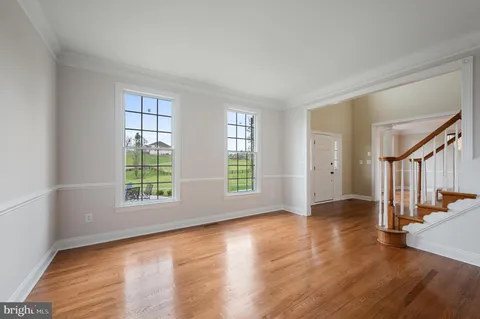 a hallway with white cabinets and wooden floor