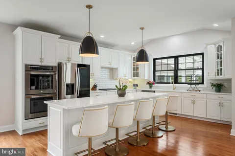 a patio with table and chairs and potted plants