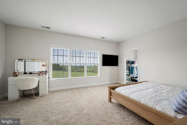 a bedroom with a large bed and windows