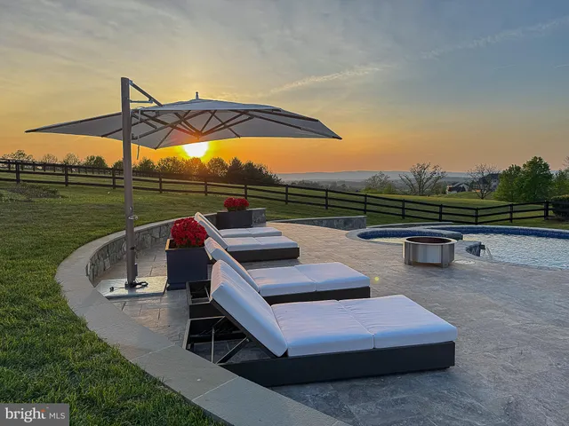 a view of a dinning table and chairs in the patio front of house
