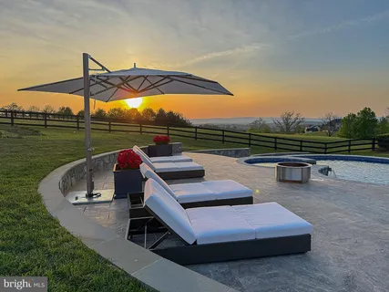 a patio with table and chairs and potted plants