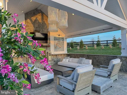 a view of a dinning table and chairs in the patio front of house