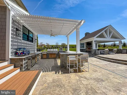 a open kitchen with stainless steel appliances kitchen island granite countertop a refrigerator a stove and a dining table with wooden floor