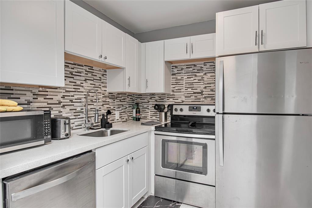 436 Fanshaw K, Unit 436 Boca Raton, FL 33434 - Photo 11 of 16 a kitchen with cabinets stainless steel appliances and counter space