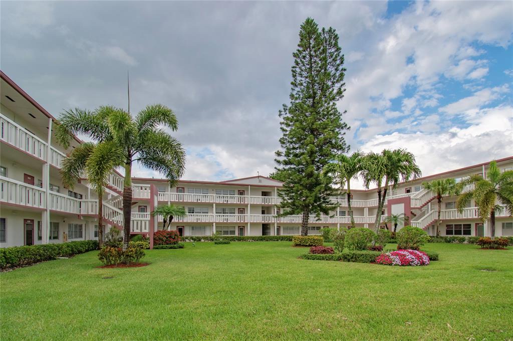 436 Fanshaw K, Unit 436 Boca Raton, FL 33434 - Photo 3 of 16 a view of a garden with a building in the background