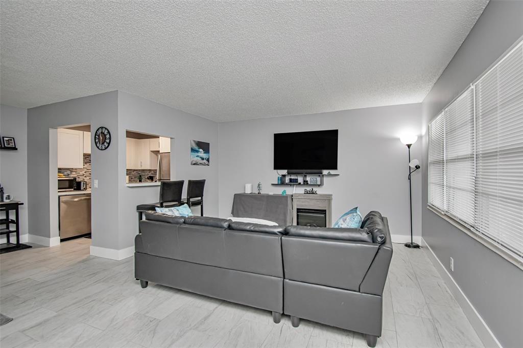 436 Fanshaw K, Unit 436 Boca Raton, FL 33434 - Photo 5 of 16 a living room with furniture and a flat screen tv