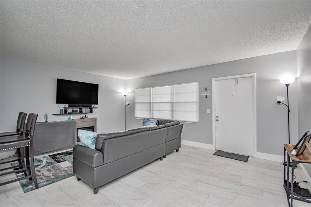 436 Fanshaw K, Unit 436 Boca Raton, FL 33434 - Photo 8 of 16 a living room with furniture and a flat screen tv