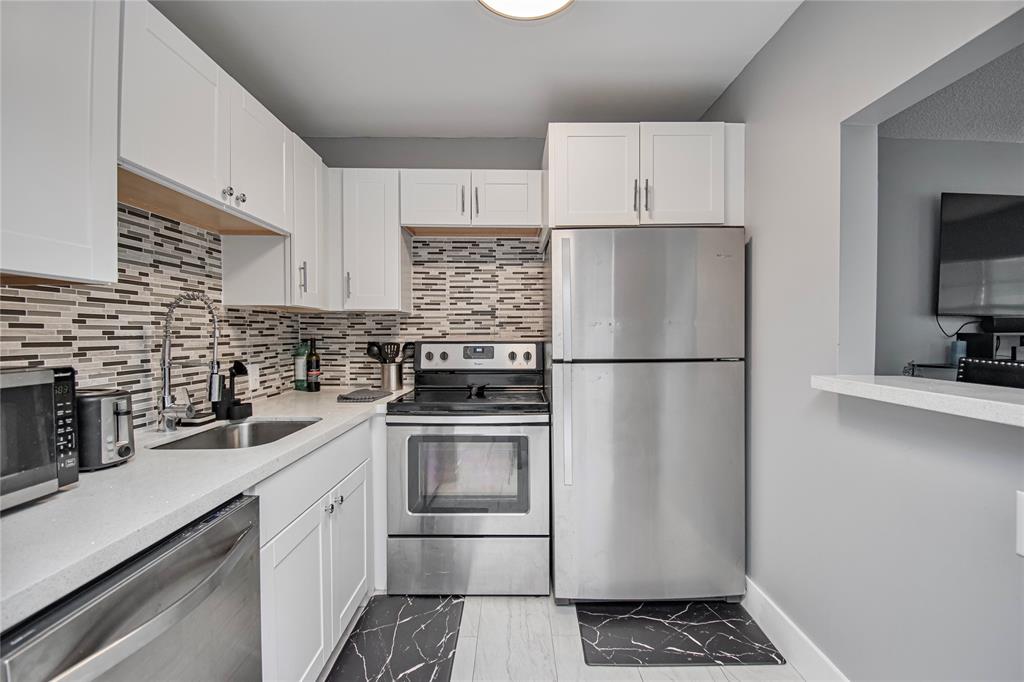 436 Fanshaw K, Unit 436 Boca Raton, FL 33434 - Photo 10 of 16 a kitchen with a refrigerator sink and cabinets