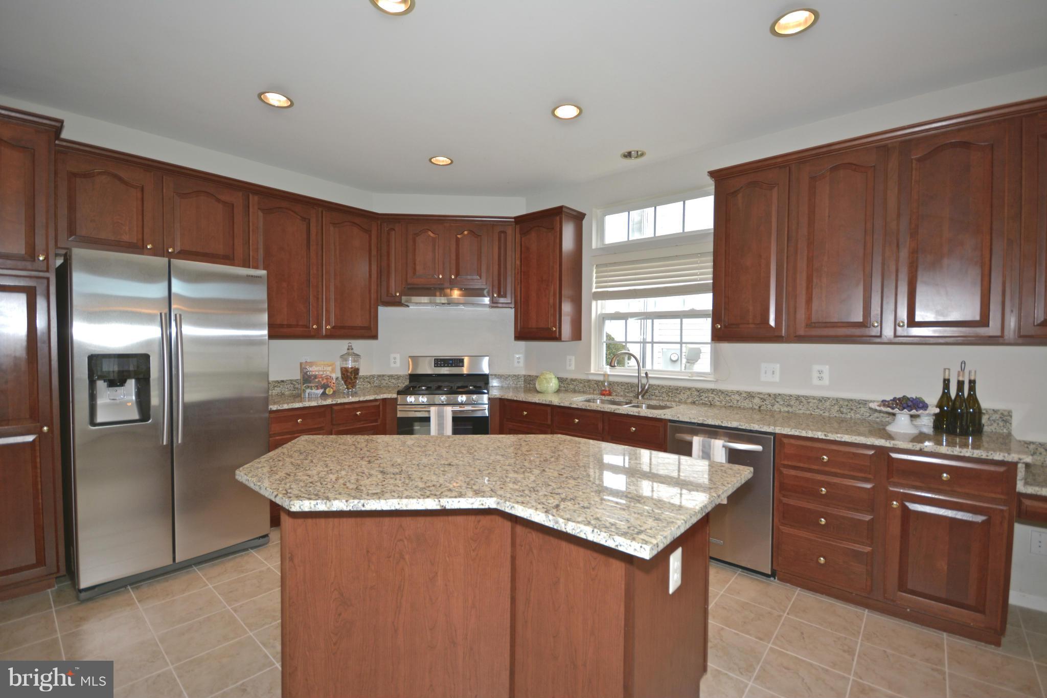 14468 Clubhouse Road Gainesville, VA 20155 - Photo 11 of 30 a kitchen with a sink a center island cabinets and stainless steel appliances