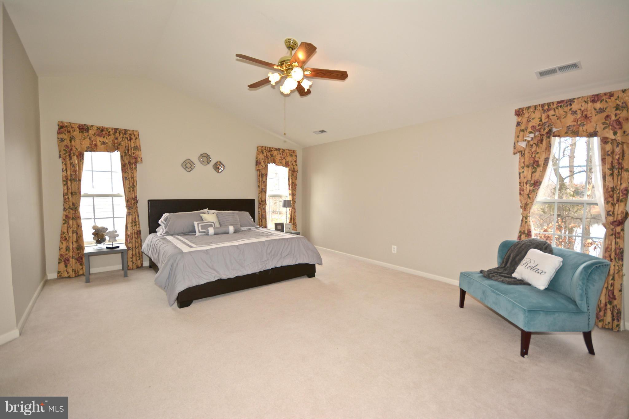 14468 Clubhouse Road Gainesville, VA 20155 - Photo 15 of 30 a bedroom with a bed a couch and a chandelier