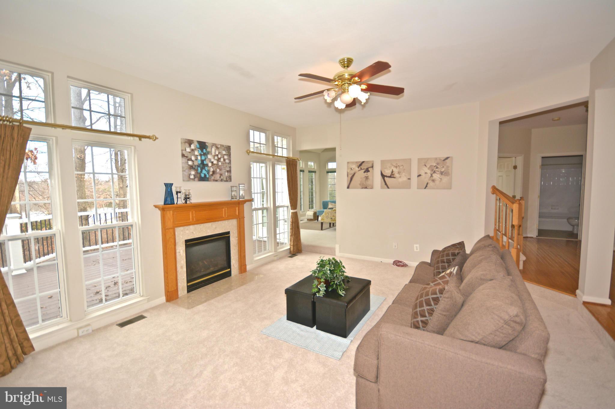 14468 Clubhouse Road Gainesville, VA 20155 - Photo 7 of 30 a living room with furniture a fireplace and a flat screen tv