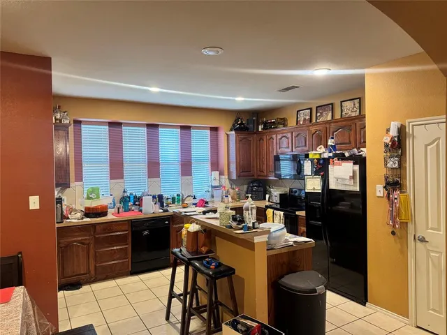 a view of a kitchen with refrigerator and dining table
