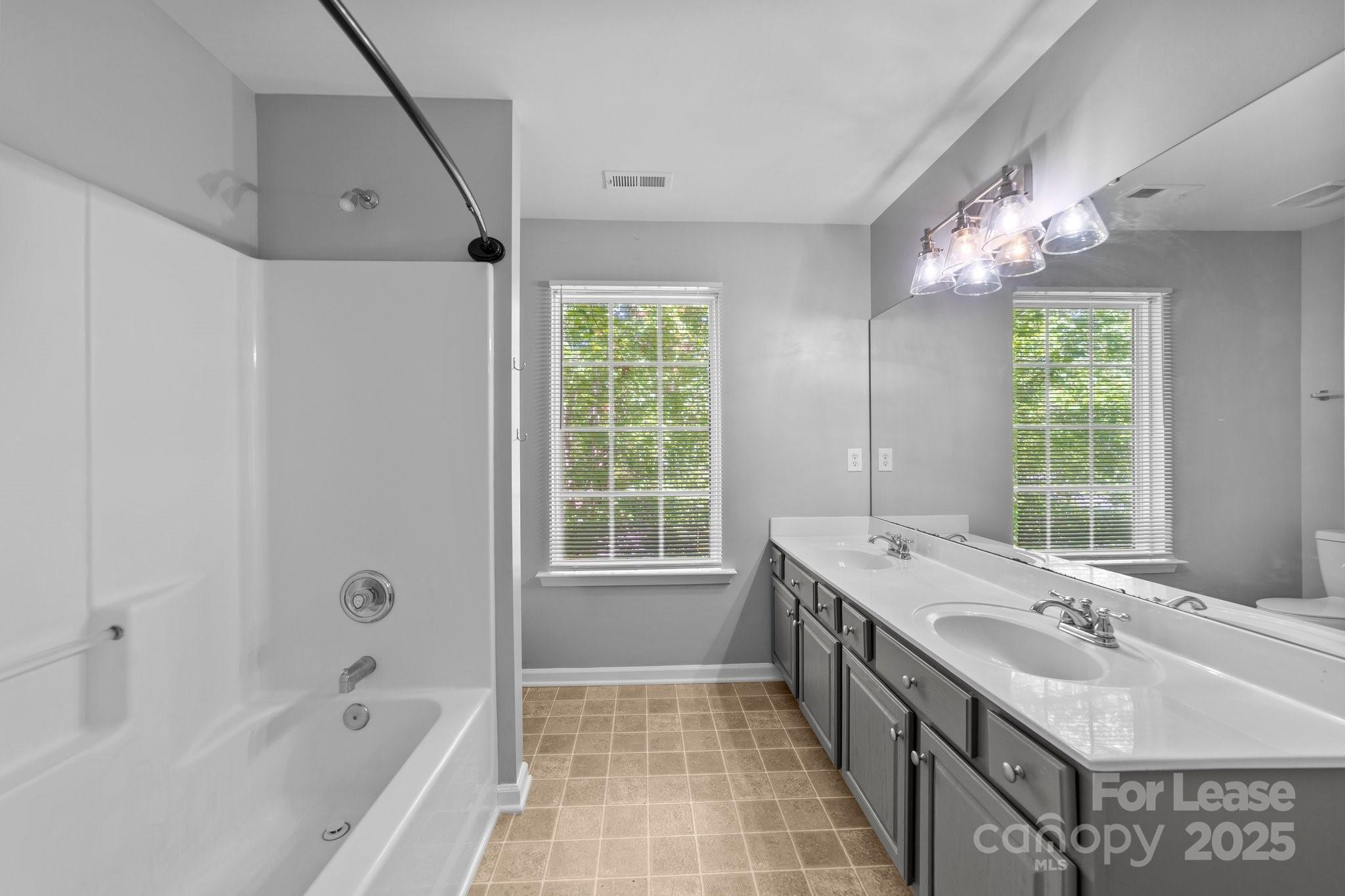 17562 Caldwell Track Drive Cornelius, NC 28031 - Photo 19 of 38 a bathroom with a tub sink and mirror