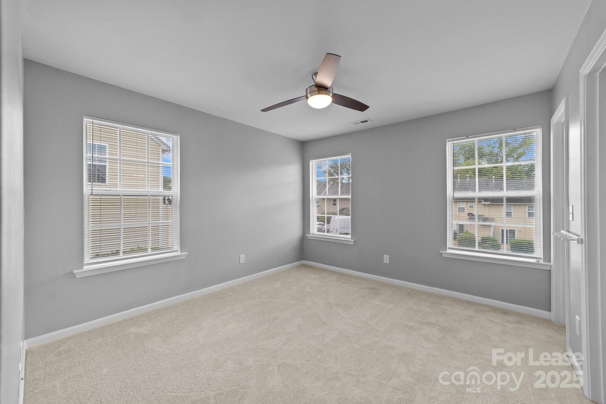 17562 Caldwell Track Drive Cornelius, NC 28031 - Photo 28 of 38 an empty room with chandelier fan and windows