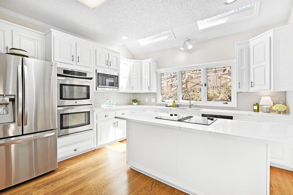 4409 Windsor Oaks Circle Marietta, GA 30066 - Photo 24 of 90 a kitchen with kitchen island granite countertop a sink cabinets stainless steel appliances and a window