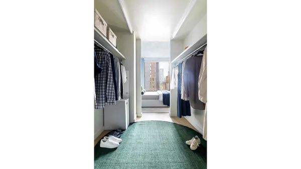 a hallway with couches and potted plant