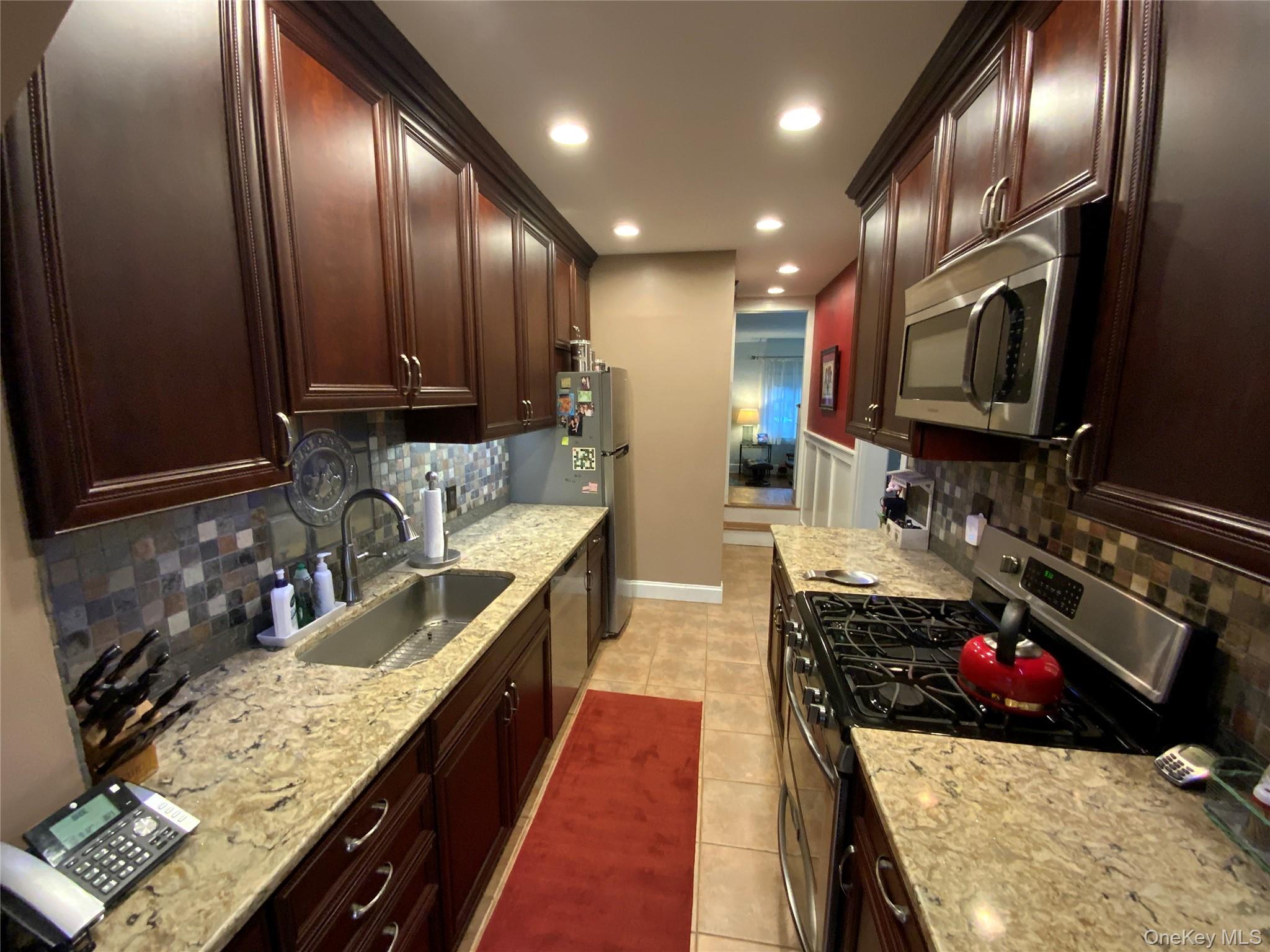 47-05 189th Street Queens, NY 11358 - Photo 11 of 41 a kitchen with stainless steel appliances granite countertop a sink stove and cabinets