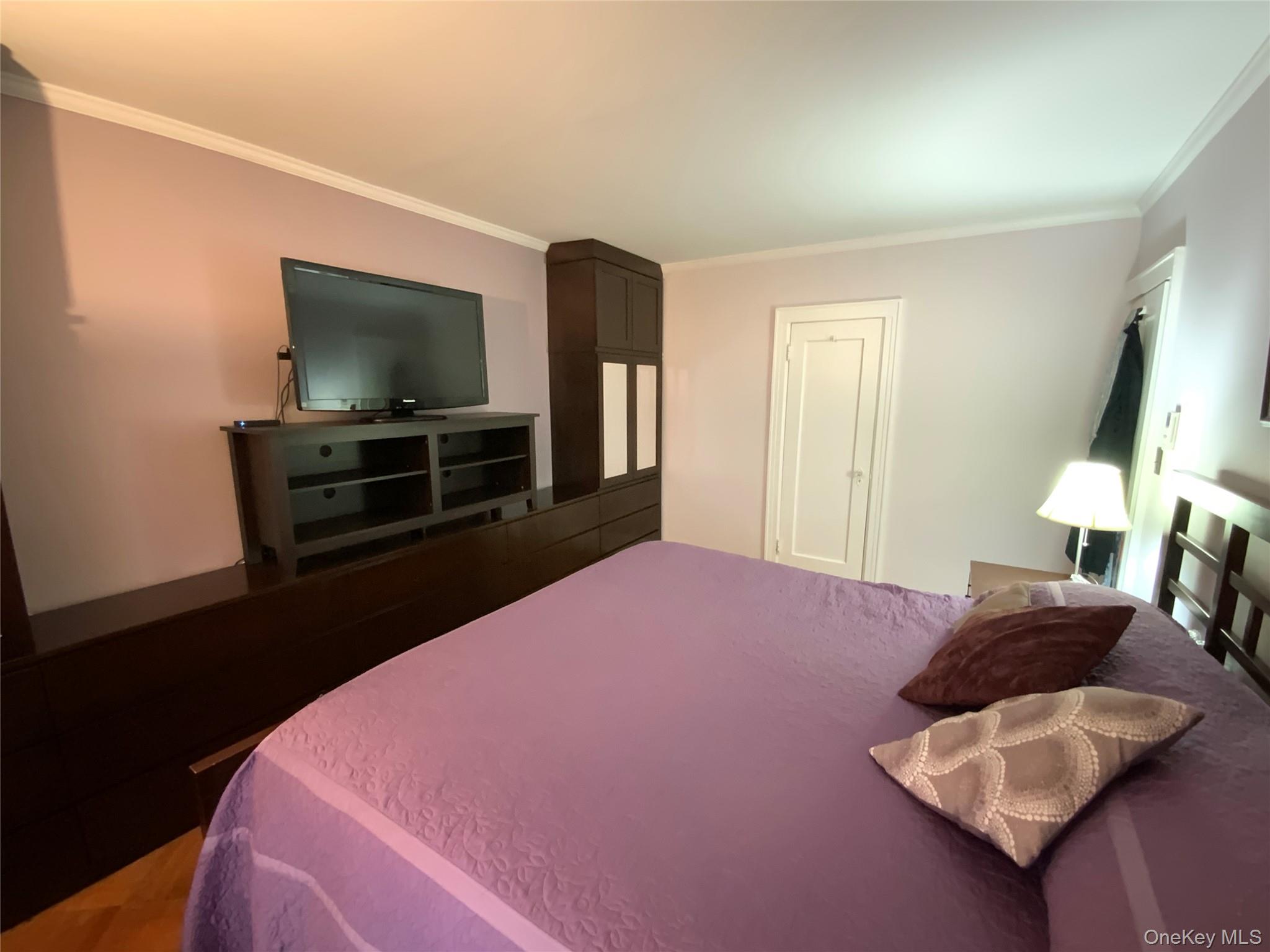 47-05 189th Street Queens, NY 11358 - Photo 24 of 41 a bedroom with a bed and a flat screen tv