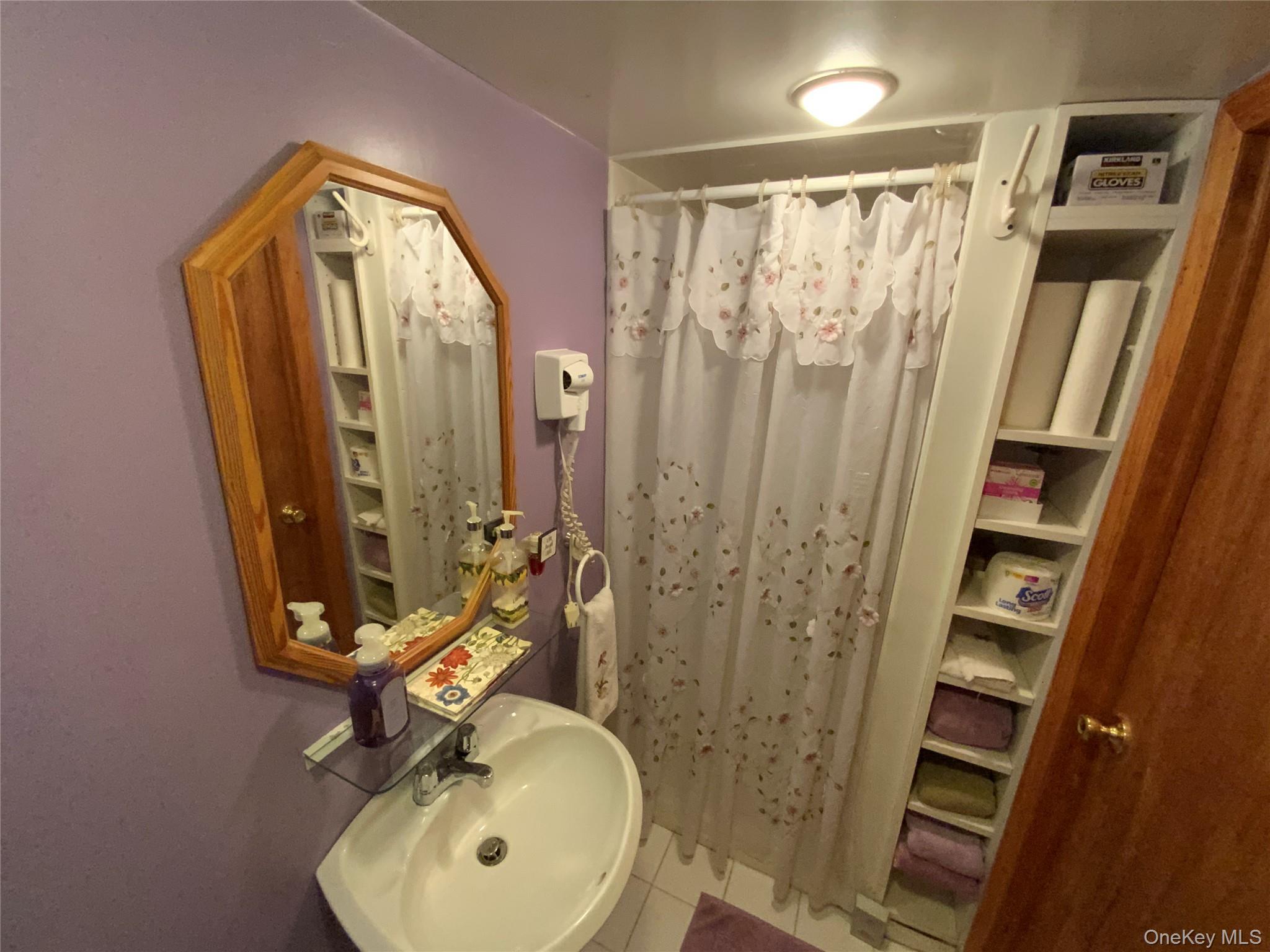 47-05 189th Street Queens, NY 11358 - Photo 35 of 41 a bathroom with a sink a mirror a vanity and shower