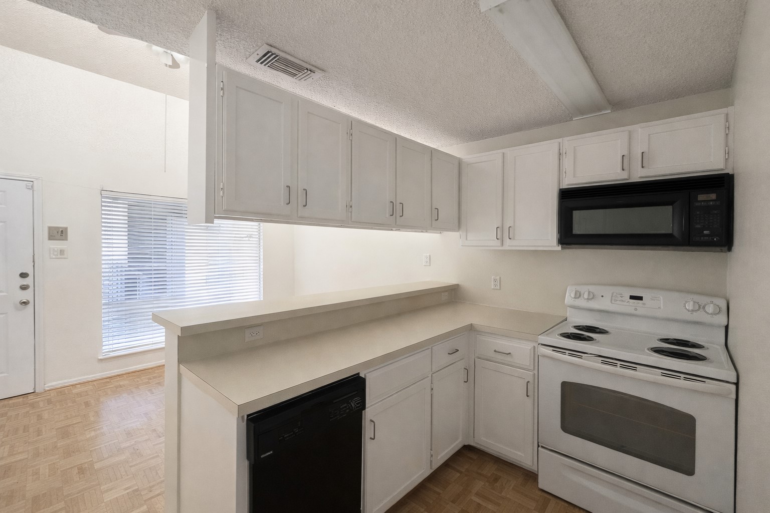 2815 Rio Grande Street, Unit 205 Austin, TX 78705 - Photo 2 of 20 a kitchen with stainless steel appliances white cabinets and a stove top oven