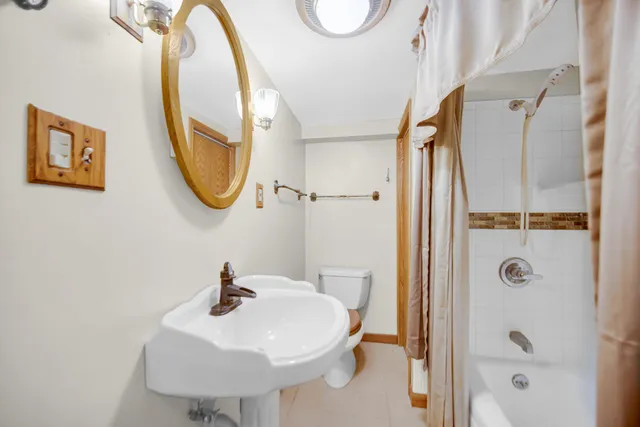 a bathroom with a sink a mirror a toilet and a shower