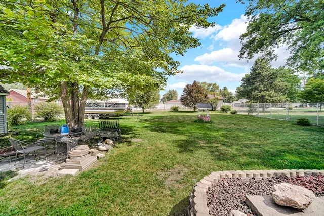 a view of a house with backyard and a tree