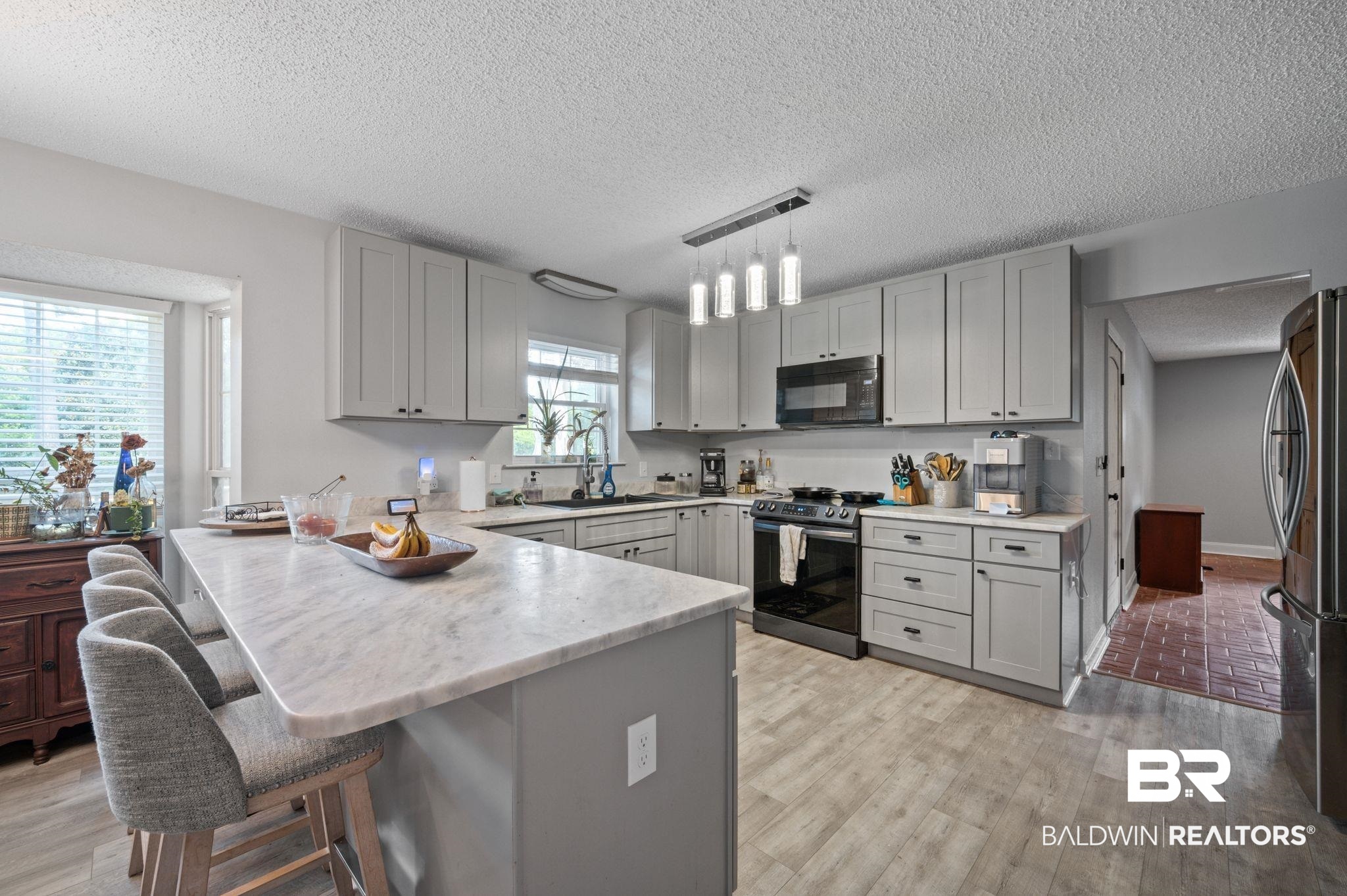 620 Southern Way Spanish Fort, AL 36527 - Photo 2 of 18 Kitchen with electric range, a breakfast bar area, kitchen peninsula, stainless steel fridge, and sink