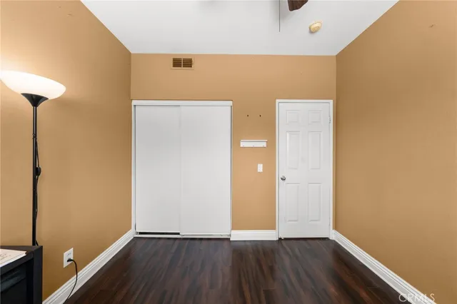 a view of a livingroom with wooden floor and a ceiling fan