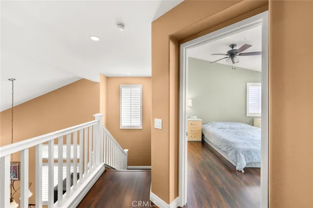 a bedroom with a bed wooden floor and window