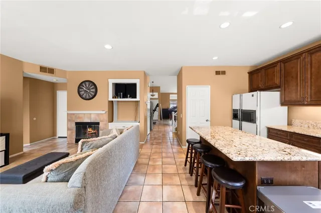 a kitchen with kitchen island granite countertop wooden cabinets and a refrigerator