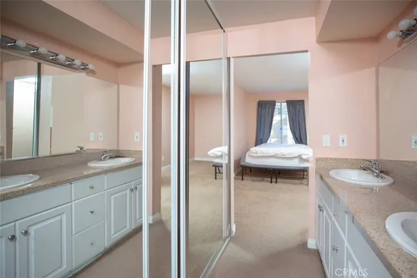 a en suite bathroom with a granite countertop sink and a mirror