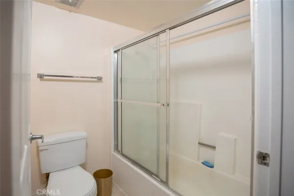 a white toilet sitting next to a bath tub