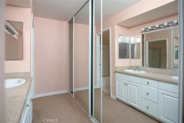 a bathroom with a granite countertop sink a mirror and a shower