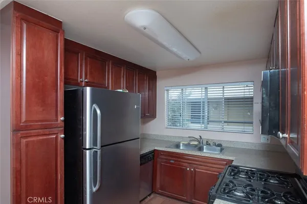 a kitchen with granite countertop a refrigerator and a sink