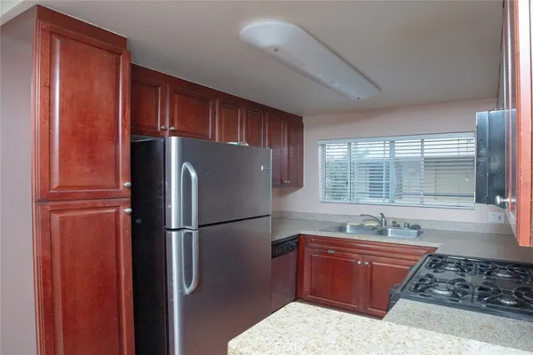 a kitchen with stainless steel appliances granite countertop a refrigerator and a sink