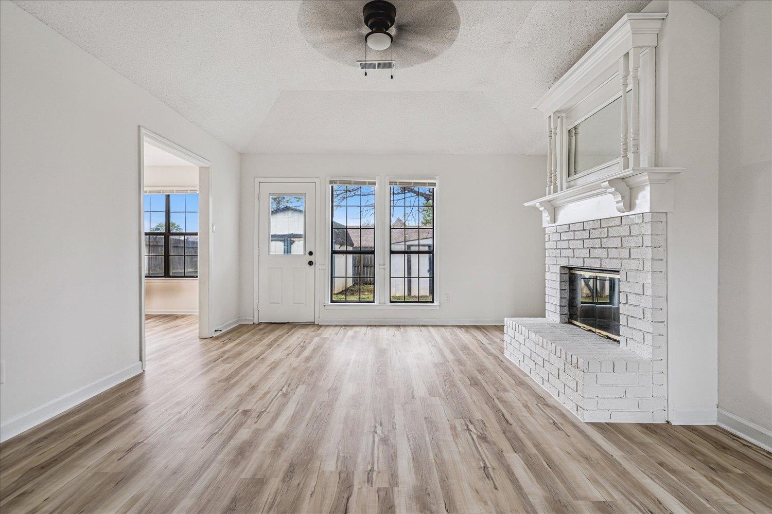 5287 Shady Ridge Drive Memphis, TN 38141 - Photo 5 of 13 Unfurnished living room with a ceiling fan, light wood finished floors, and a fireplace
