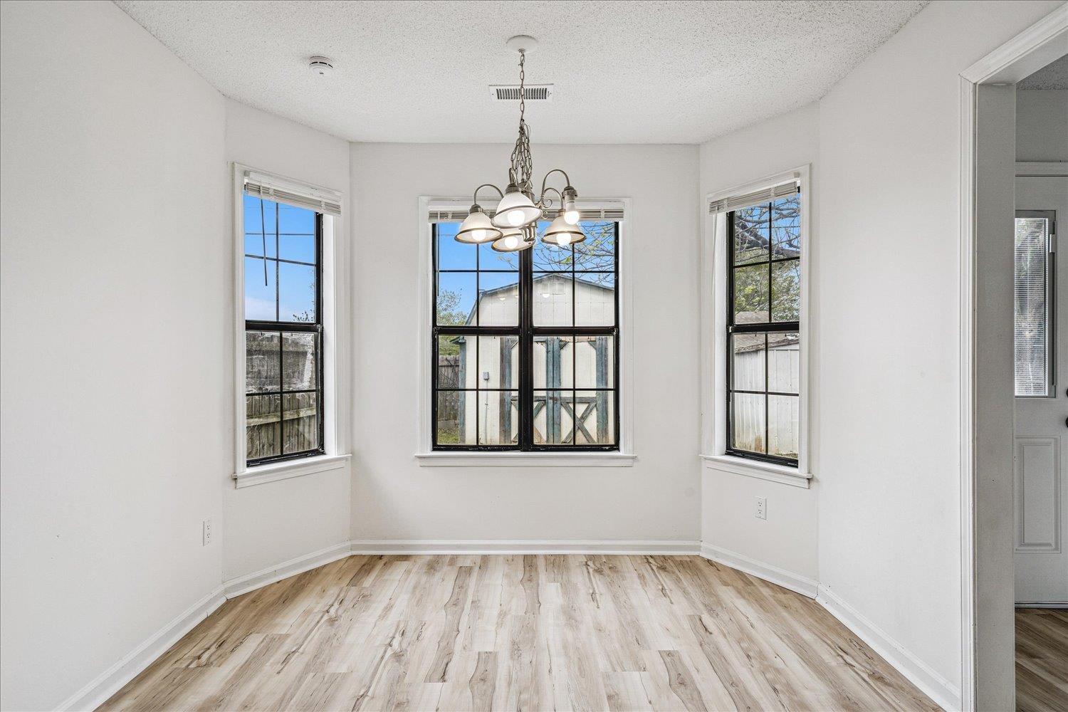 5287 Shady Ridge Drive Memphis, TN 38141 - Photo 8 of 13 Unfurnished dining area featuring hanging lights, light wood-style flooring, and a textured ceiling