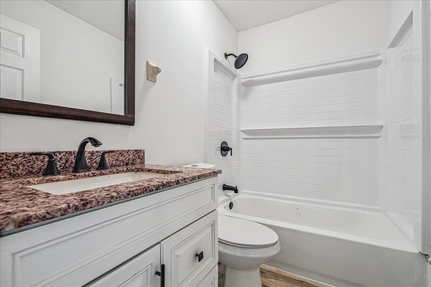 5287 Shady Ridge Drive Memphis, TN 38141 - Photo 10 of 13 Full bathroom featuring vanity, shower / washtub combination, a textured ceiling, and light wood-type flooring