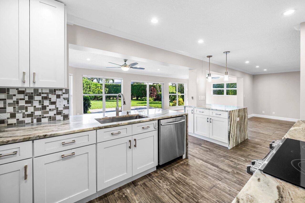 401 French Royale Circle Atlantis, FL 33462 - Photo 13 of 47 a large kitchen with kitchen island white cabinets and glass door