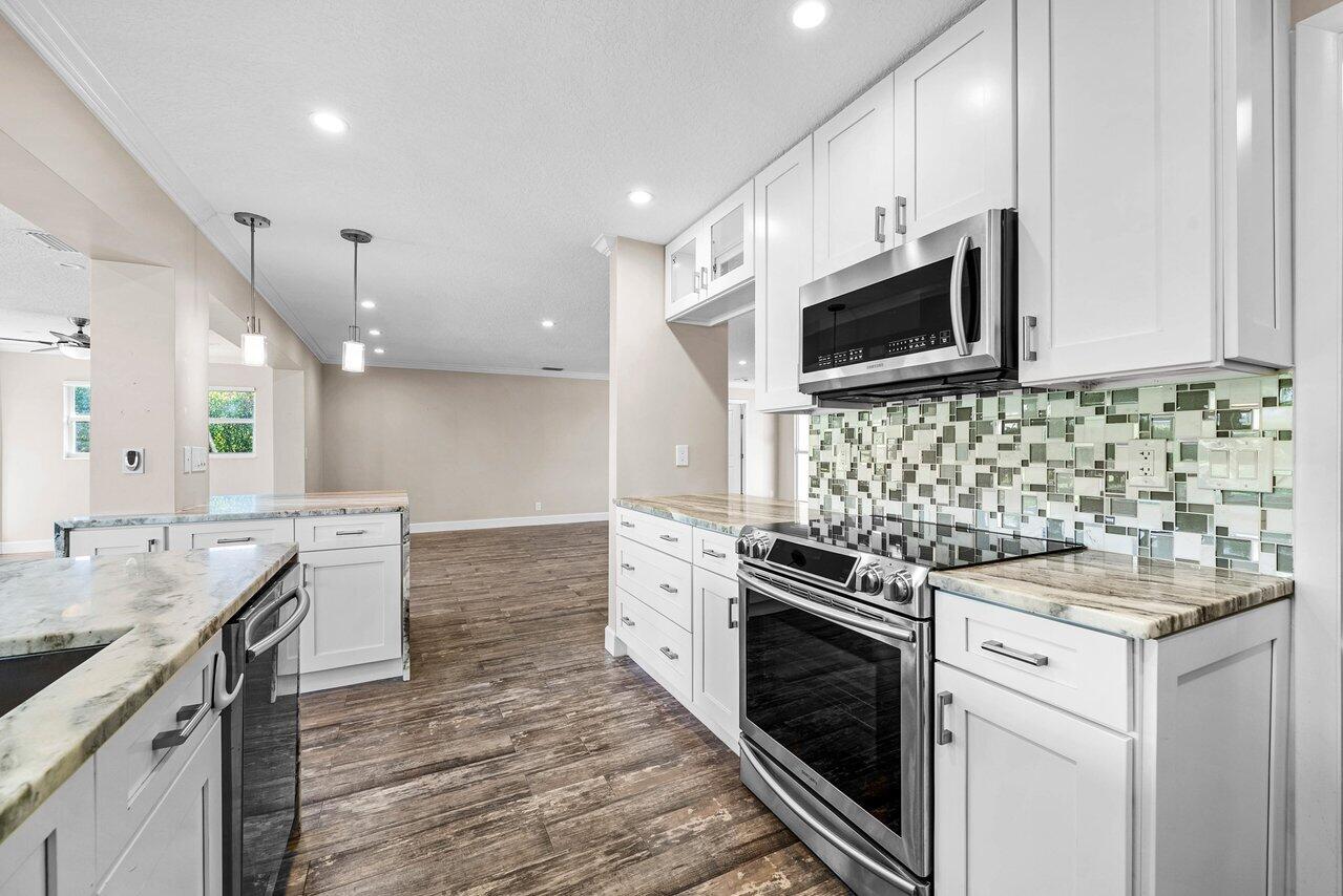 401 French Royale Circle Atlantis, FL 33462 - Photo 17 of 47 a kitchen with a sink stove and microwave