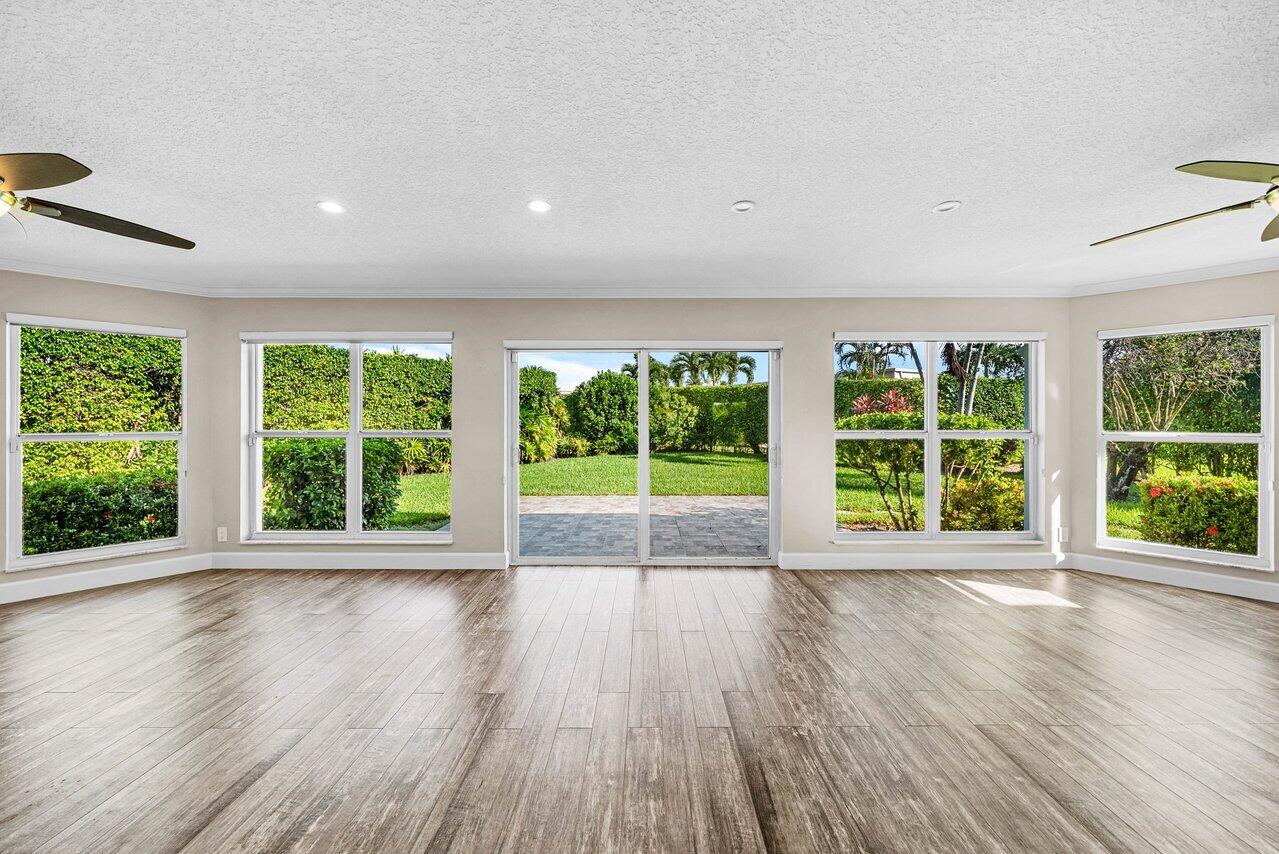 401 French Royale Circle Atlantis, FL 33462 - Photo 18 of 47 a view of an empty room with wooden floor and a window