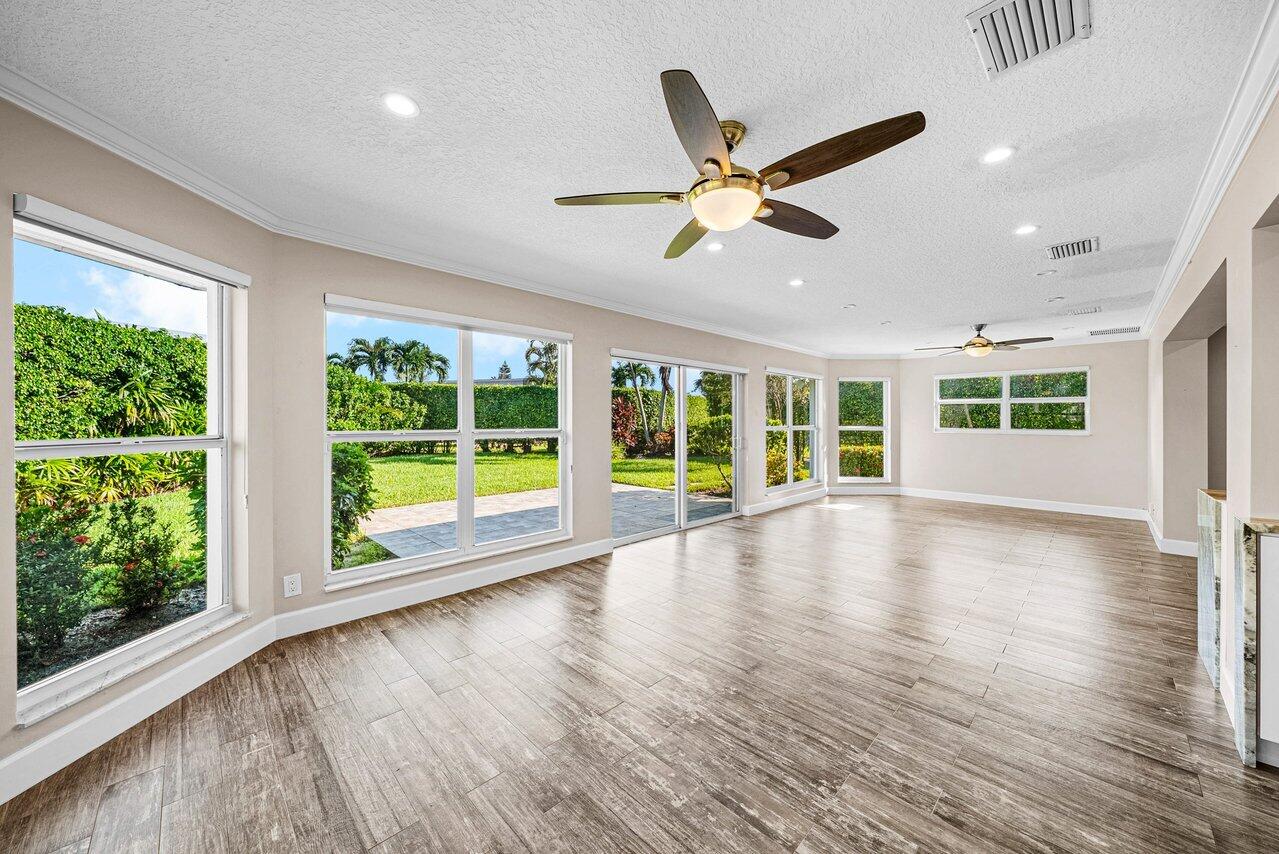 401 French Royale Circle Atlantis, FL 33462 - Photo 19 of 47 a view of an empty room with wooden floor and a window
