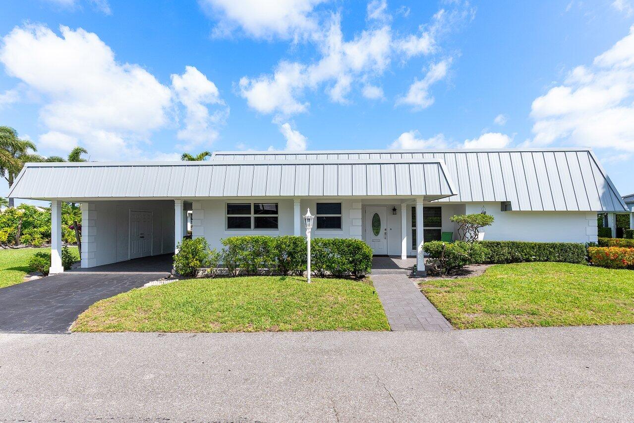 401 French Royale Circle Atlantis, FL 33462 - Photo 2 of 47 a front view of a house with a yard and potted plants