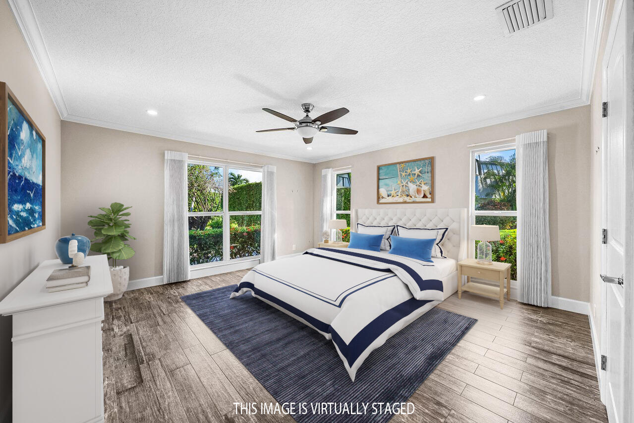 401 French Royale Circle Atlantis, FL 33462 - Photo 24 of 47 a bed sitting in a spacious bedroom next to a window