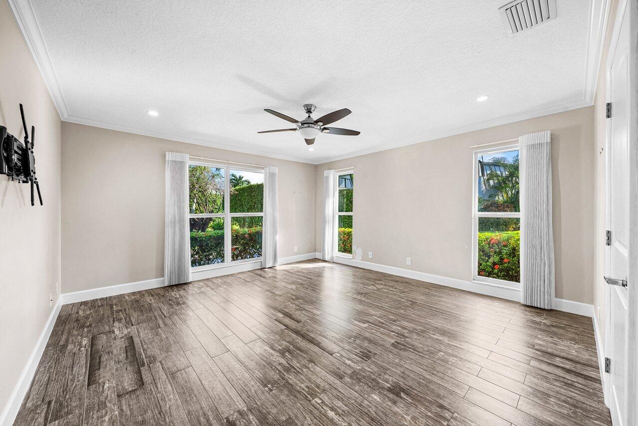 401 French Royale Circle Atlantis, FL 33462 - Photo 25 of 47 a view of an empty room with a window and wooden floor