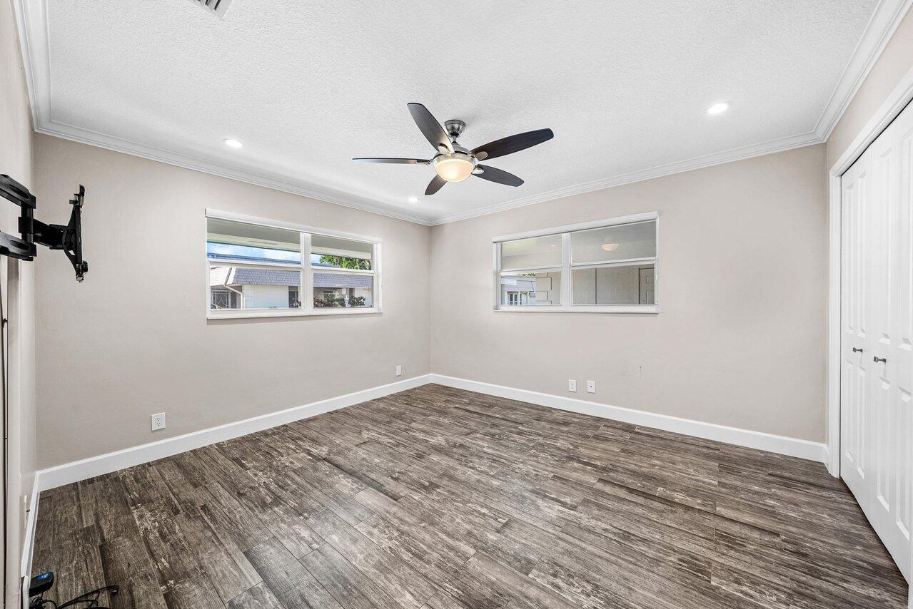 401 French Royale Circle Atlantis, FL 33462 - Photo 31 of 47 a view of empty room with wooden floor and fan