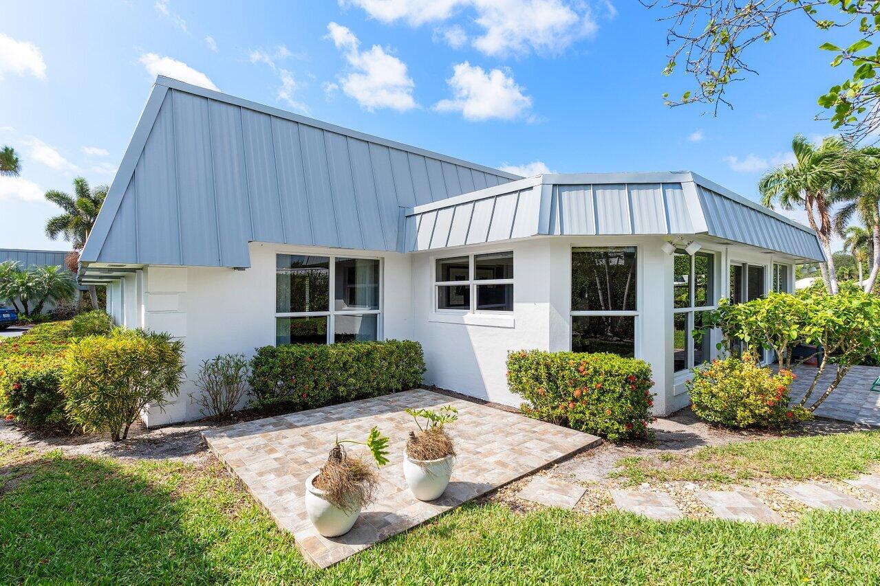 401 French Royale Circle Atlantis, FL 33462 - Photo 36 of 47 a front view of a house with garden